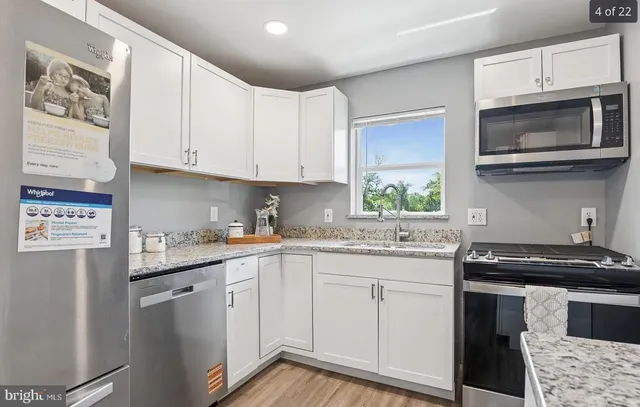 a kitchen with stainless steel appliances granite countertop a stove a sink and a microwave