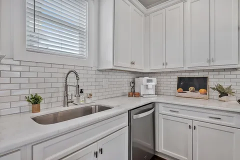 a kitchen with stainless steel appliances white cabinets and a sink
