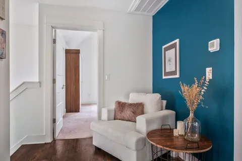 a living room with furniture flowerpot and wooden floor