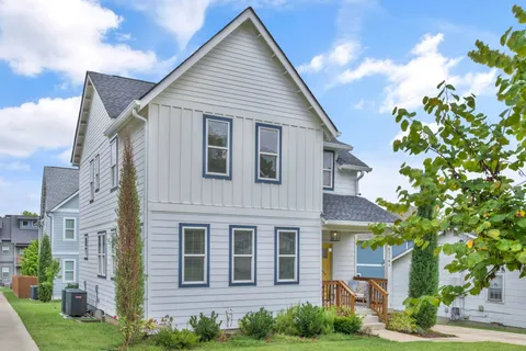 a view of a big house with plants and garden