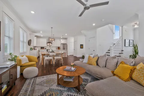a living room with furniture kitchen view and a chandelier