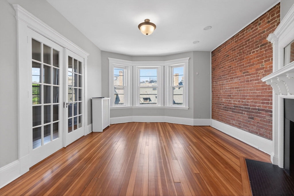 16 Garrison Road, Unit 5 Brookline, MA 02445 - Photo 2 of 14 a view of an empty room with wooden floor and a window
