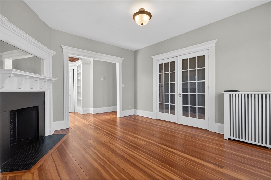 16 Garrison Road, Unit 5 Brookline, MA 02445 - Photo 3 of 14 a view of an empty room with wooden floor and a fireplace