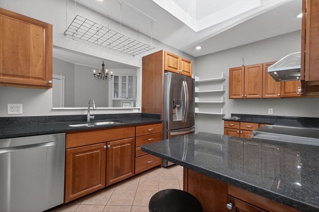 16 Garrison Road, Unit 5 Brookline, MA 02445 - Photo 5 of 14 a kitchen with stainless steel appliances granite countertop a sink and refrigerator