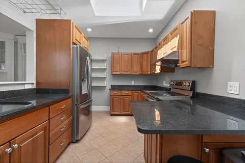 a kitchen with stainless steel appliances granite countertop a sink a stove and a refrigerator