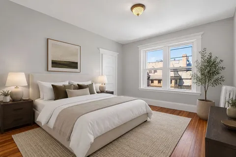 a bedroom with bed and a large window