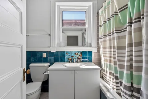 a bathroom with a sink a toilet and shower curtain