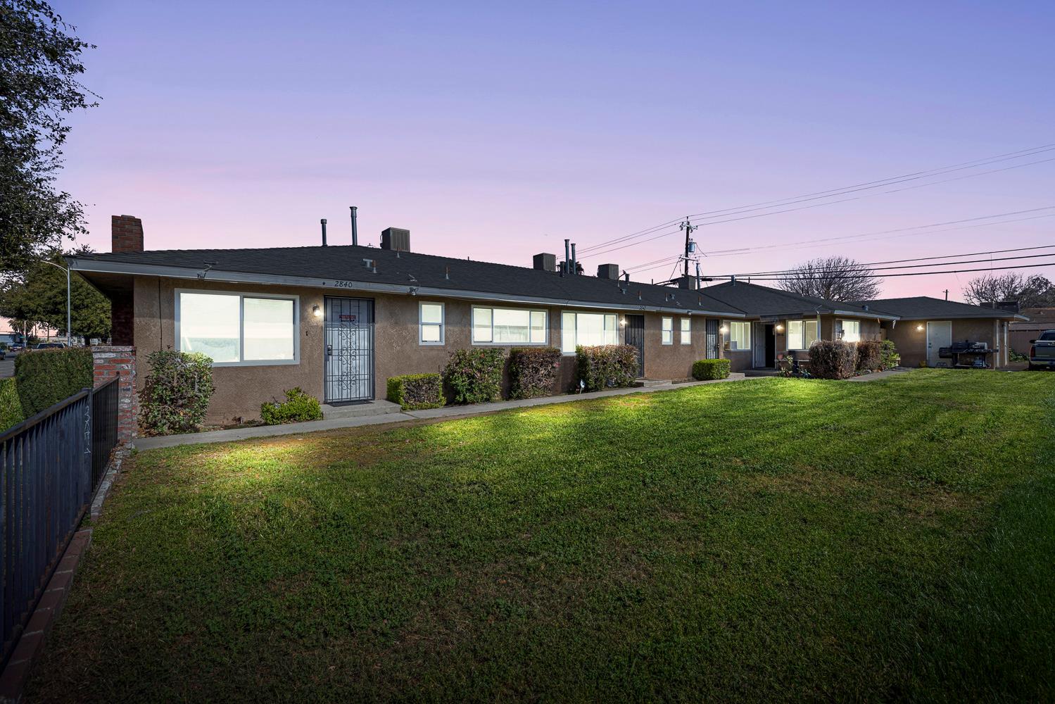 a front view of a house with a yard and potted plants