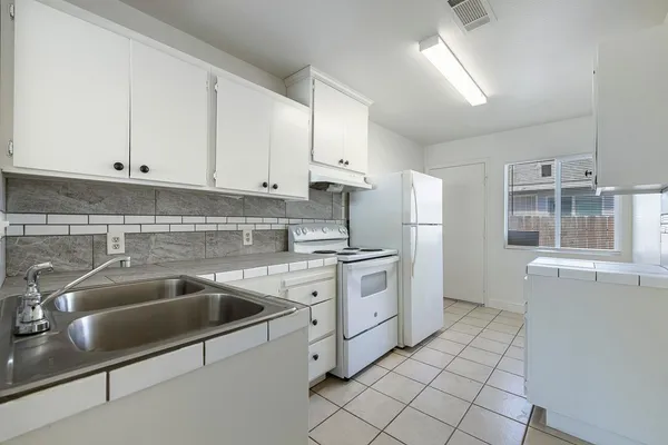 a kitchen with cabinets and white appliances