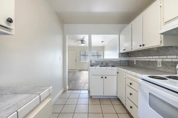 a kitchen with granite countertop white cabinets and white appliances