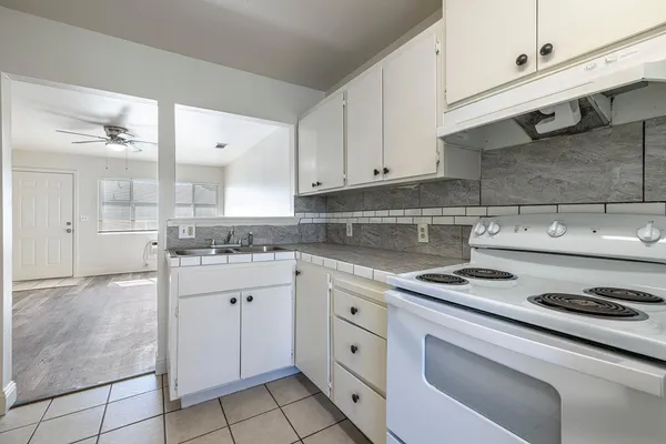 a kitchen with granite countertop white cabinets and white appliances