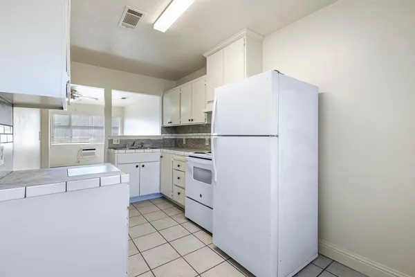 a kitchen with white cabinets and white appliances