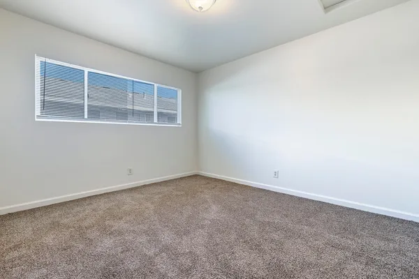 an empty room with closet and mirror