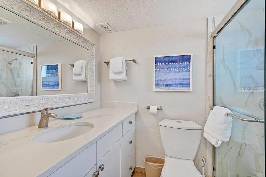 6154 Midnight Pass Road, Unit 206 Sarasota, FL 34242 - Photo 6 of 9 a bathroom with a toilet sink and mirror