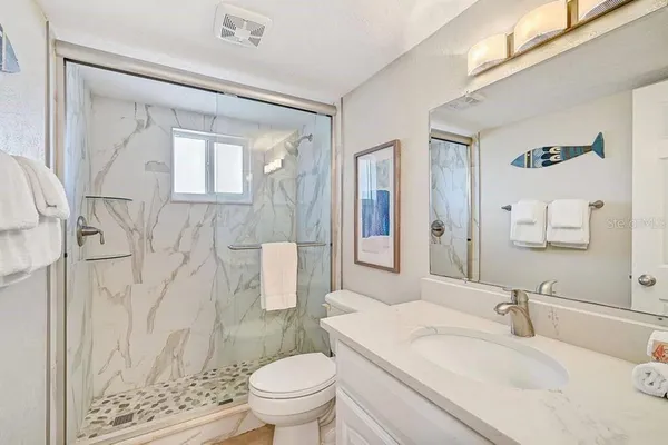 a bathroom with a sink toilet vanity and shower
