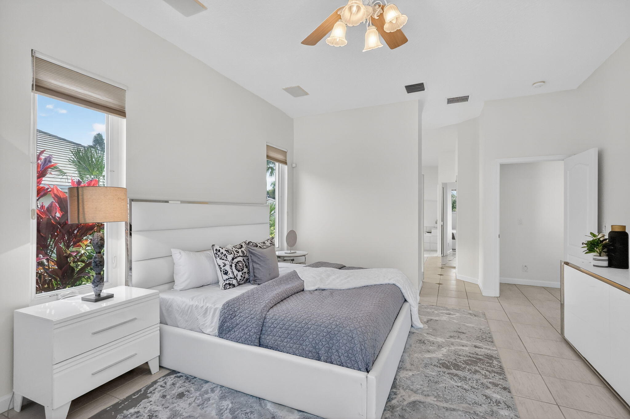 18981 Southeast Outrigger Lane Jupiter, FL 33458 - Photo 36 of 79 a bedroom with a large bed and a chandelier