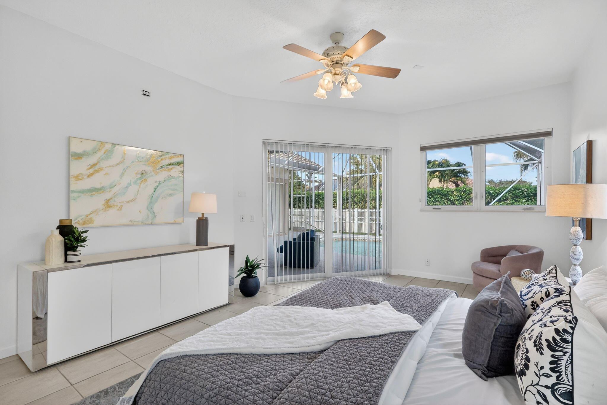 18981 Southeast Outrigger Lane Jupiter, FL 33458 - Photo 38 of 79 a bedroom with a bed and a chandelier