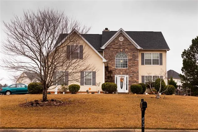 a front view of house with yard covered in snow