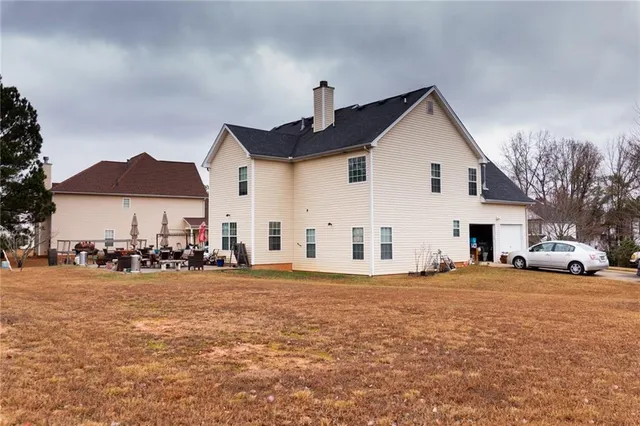 a view of a house with a yard and large trees