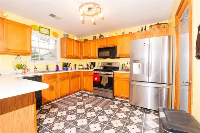a kitchen with stainless steel appliances granite countertop a refrigerator a sink and a stove