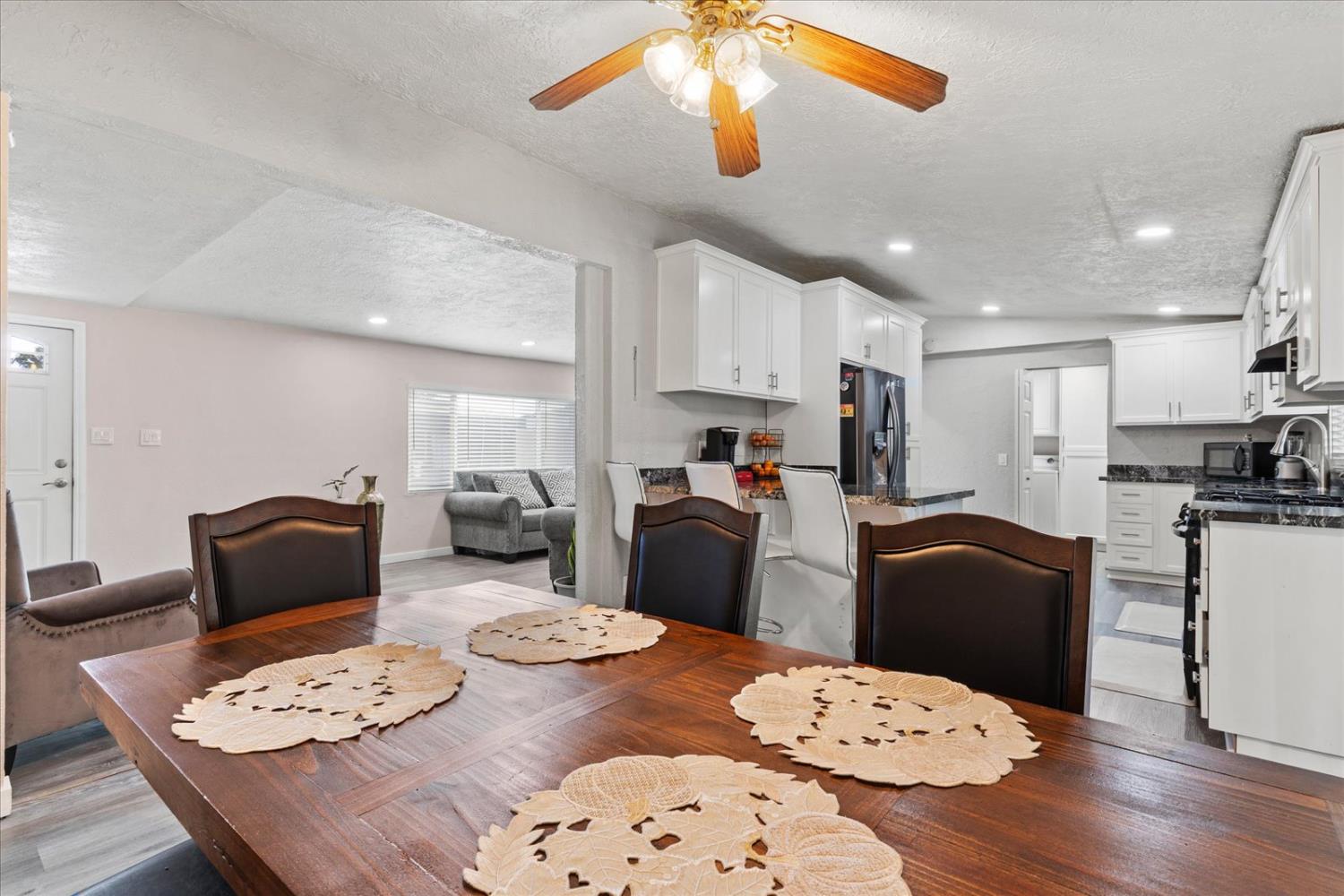 159 Village Circle Sacramento, CA 95838 - Photo 13 of 38 a kitchen with stainless steel appliances kitchen island granite countertop a refrigerator a stove a sink dishwasher a dining table and chairs with wooden floor