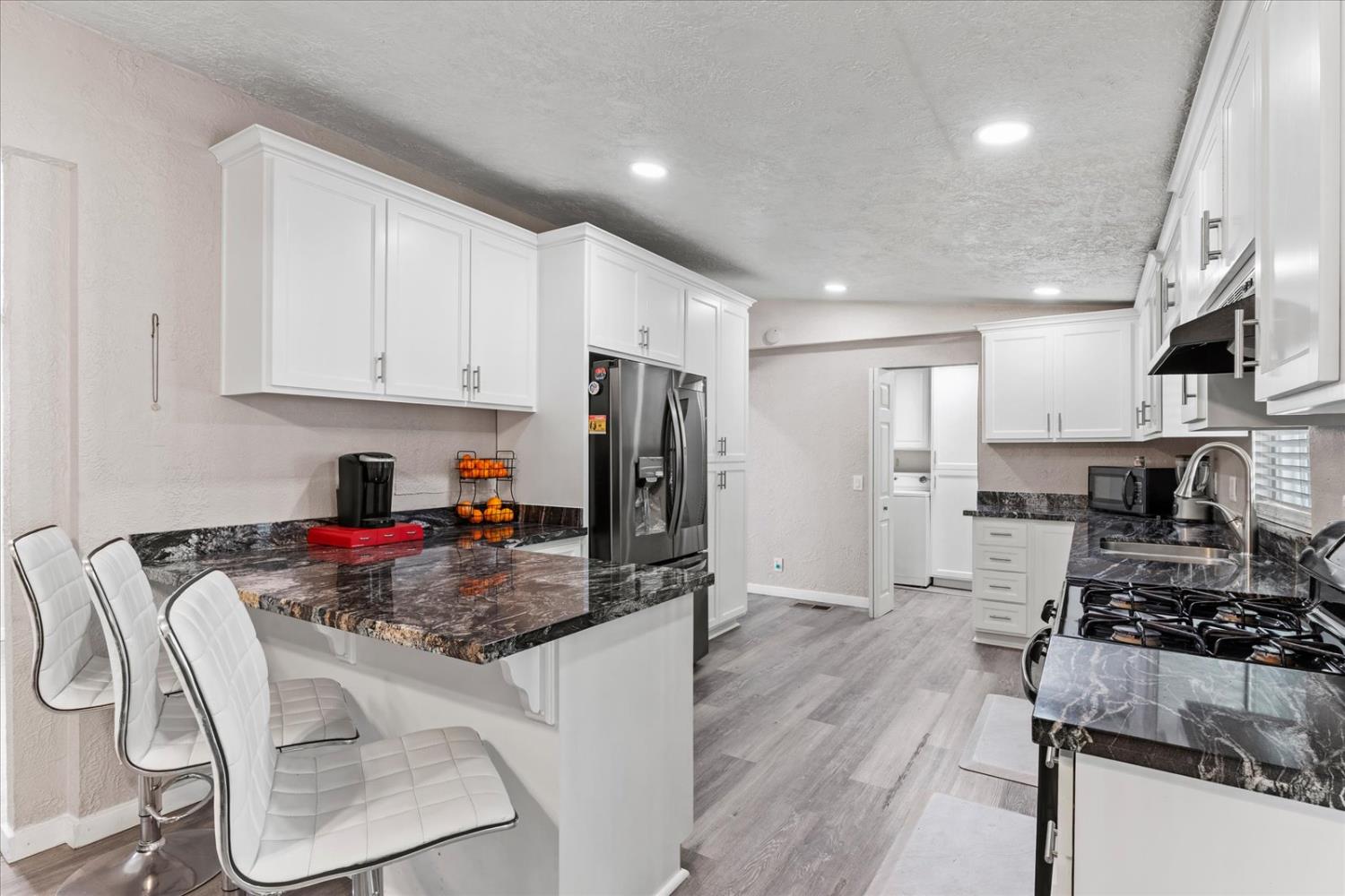 159 Village Circle Sacramento, CA 95838 - Photo 15 of 38 a kitchen with stainless steel appliances granite countertop a stove top oven a refrigerator a sink and white cabinets with wooden floor