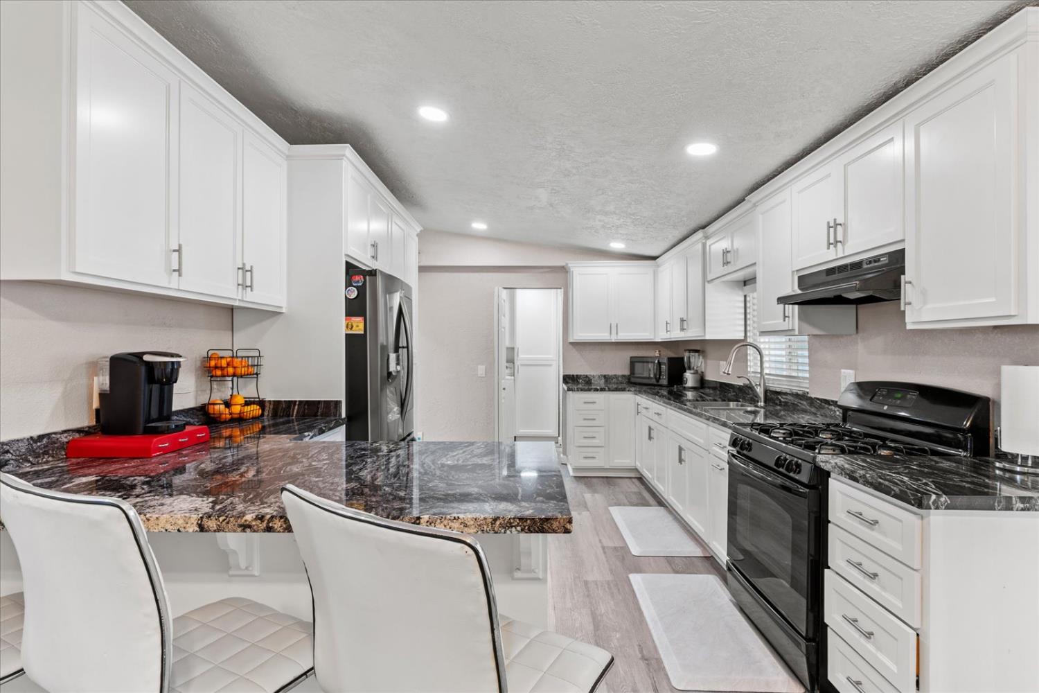 159 Village Circle Sacramento, CA 95838 - Photo 16 of 38 a kitchen with granite countertop a sink stove and cabinets