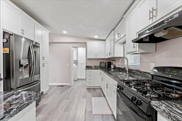 a kitchen with stainless steel appliances granite countertop a stove and a refrigerator