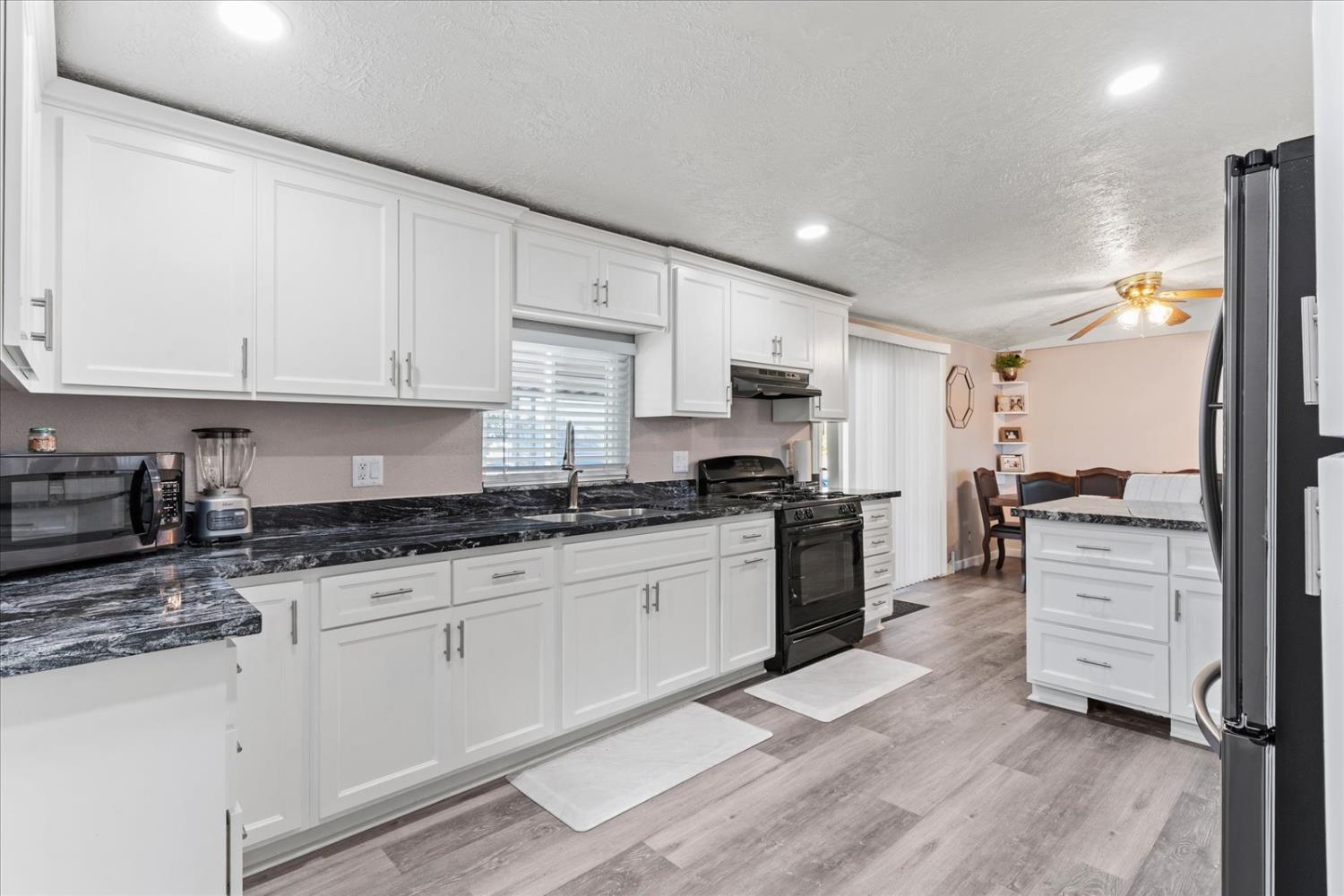 159 Village Circle Sacramento, CA 95838 - Photo 19 of 38 a kitchen with granite countertop a sink stove and cabinets