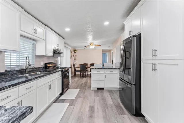 a kitchen with stainless steel appliances a refrigerator sink and cabinets