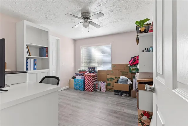 a view of a workspace with furniture and a window