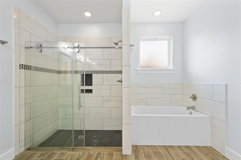 3807 Winding Road Arlington, TX 76016 - Photo 14 of 23 Bathroom featuring a glass-enclosed shower with subway tile and a mosaic accent, a built-in tub with brushed nickel fixtures, wood-finish flooring, and a frosted window