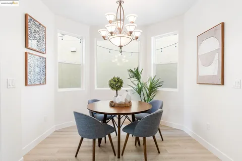 a dining room with furniture potted plants and wooden floor