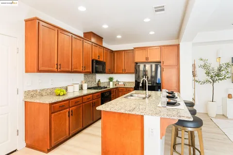 a kitchen with kitchen island granite countertop a sink and cabinets