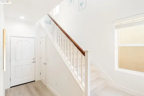 a view of staircase with railing and white walls