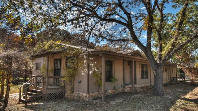 a backyard of a house with lots of green space and fountain