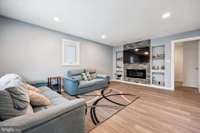 a living room with furniture a flat screen tv and a fireplace