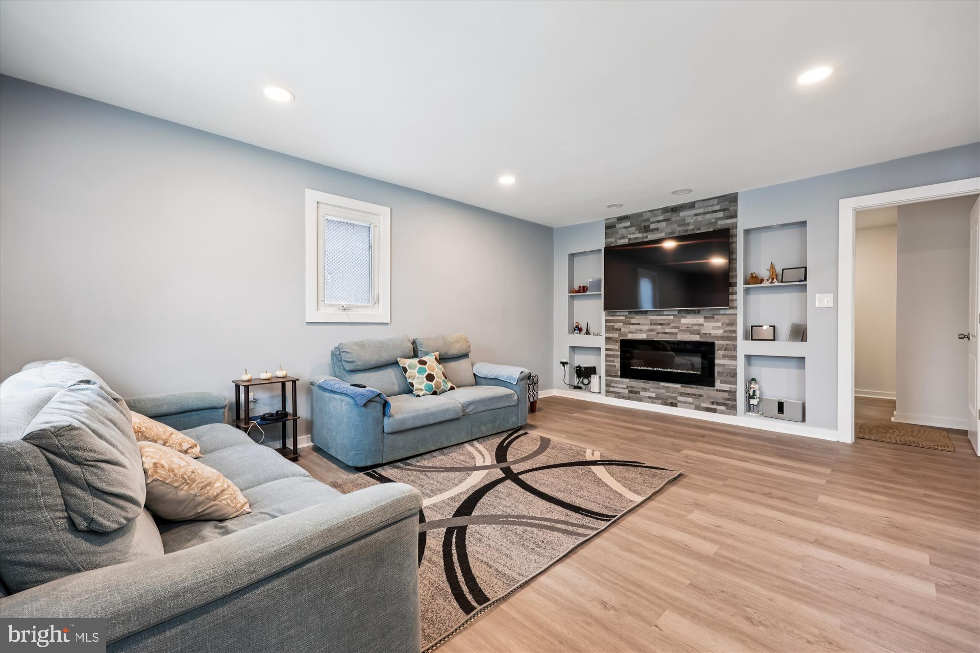 8313 Shady Spring Drive Gaithersburg, MD 20877 - Photo 2 of 30 a living room with furniture a flat screen tv and a fireplace