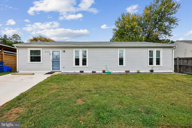 a backyard of a house with large trees and table