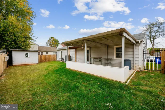 a view of a house with a yard and a large tree