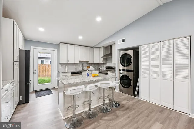 a kitchen with stainless steel appliances granite countertop a refrigerator and a stove top oven