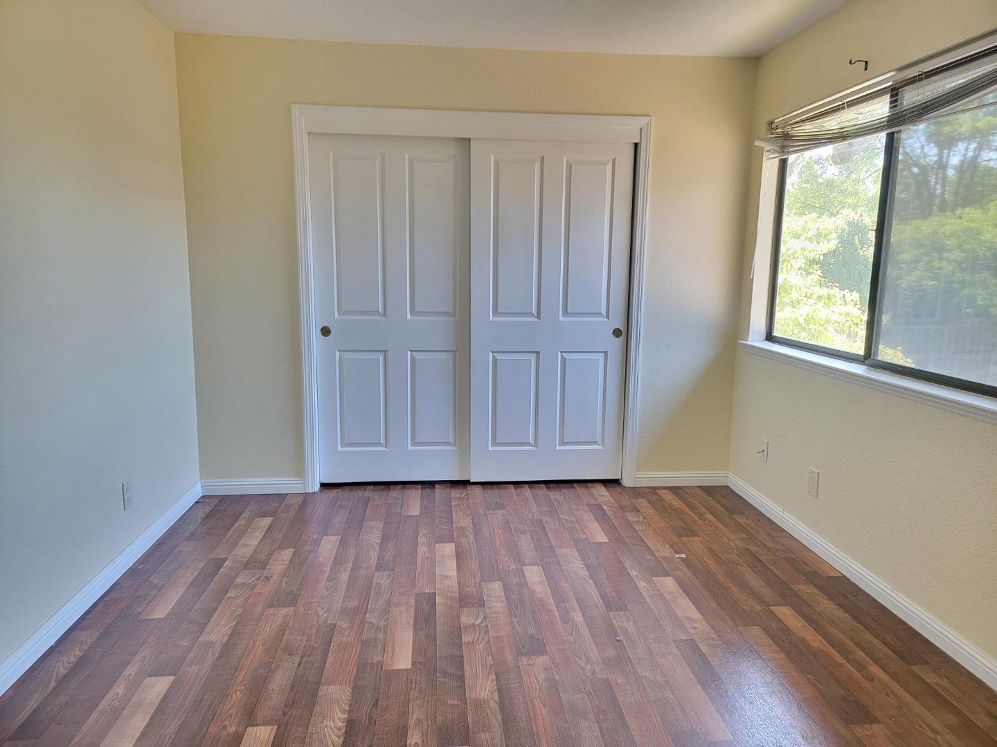 801 Nash Road, Unit A9 Hollister, CA 95023 - Photo 6 of 13 a view of an empty room with wooden floor and a window