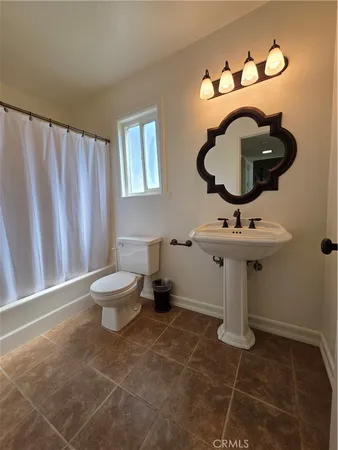 a bathroom with a sink toilet and mirror
