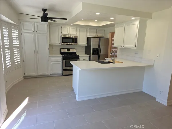 a view of kitchen with refrigerator stove microwave and cabinets