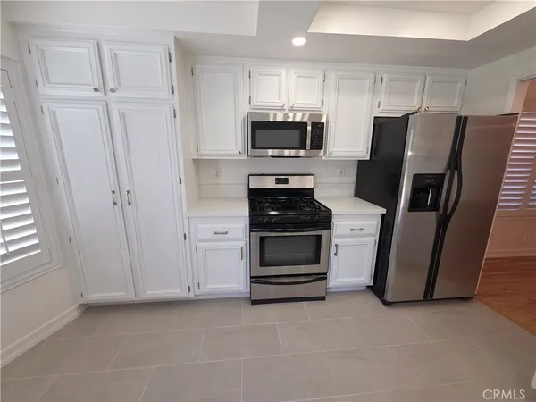 a kitchen with white cabinets and stainless steel appliances