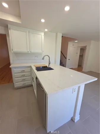 a kitchen that has a sink a stove and a refrigerator