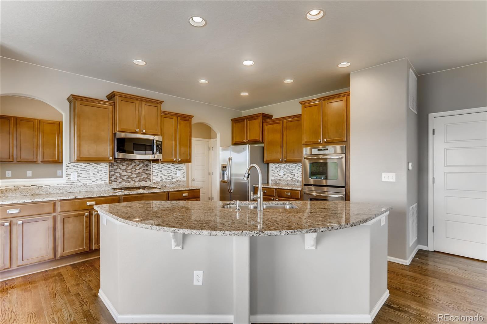 8627 Raspberry Drive Frederick, CO 80504 - Photo 5 of 33 a kitchen with stainless steel appliances granite countertop a sink a stove and a refrigerator