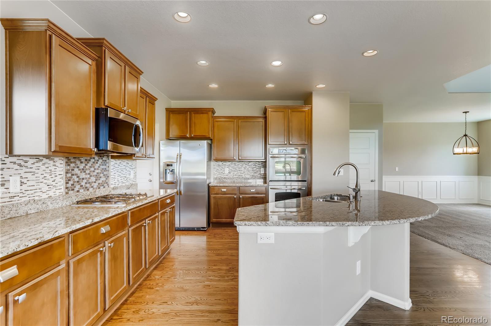 8627 Raspberry Drive Frederick, CO 80504 - Photo 6 of 33 a kitchen with stainless steel appliances granite countertop a sink a stove top oven a counter space and cabinets