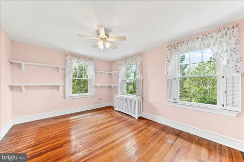 an empty room with a window and a fan