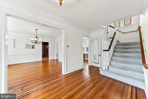 a view of a room with wooden floor staircase and a kitchen
